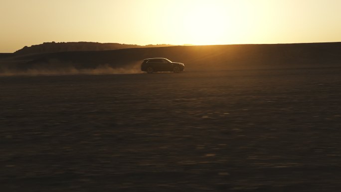 在哈密大海道雅丹风蚀地貌夕阳中行驶的汽车