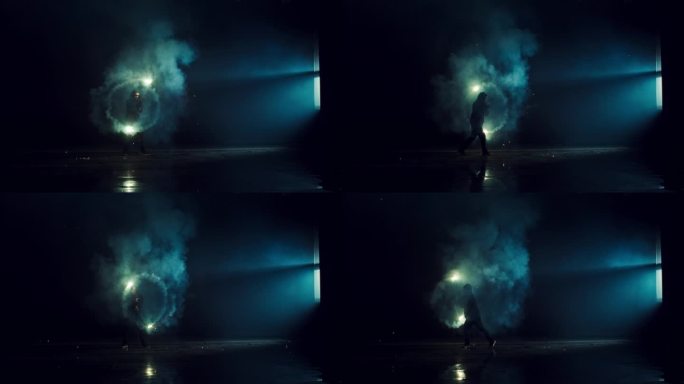 专业的火焰表演者在马戏团黑暗的舞台上旋转火球。具有烟雾和实用火焰效果的创意艺术表演。穆迪电影镜头与才