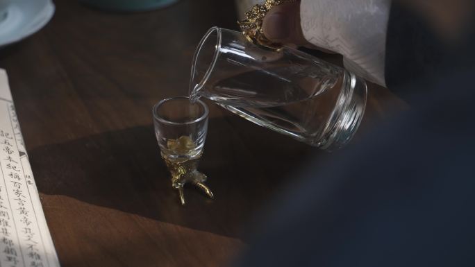 古人倒白酒进玻璃酒杯