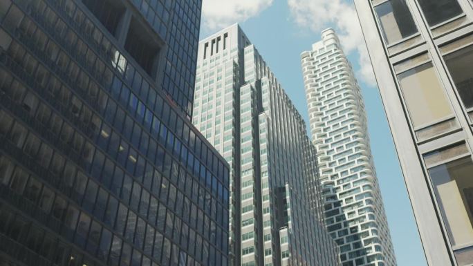 纽约一组现代办公大楼的低角度视图。曼哈顿摩天大楼在蓝天背景与轻云。旅游理念，旅游，热门商务目的地