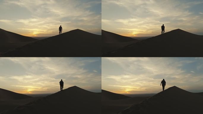 库木塔格沙漠上夕阳晚霞中徒步的人爬沙山