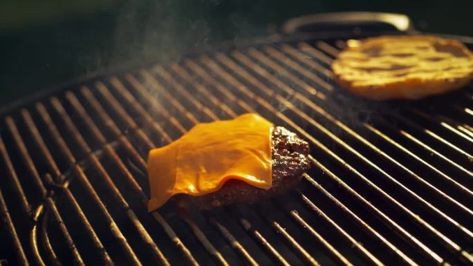 美味的肉饼正在户外烧烤烤架上准备。碎牛肉是用来做汉堡的。厨师正在加一片奶酪。超级慢动作特写镜头