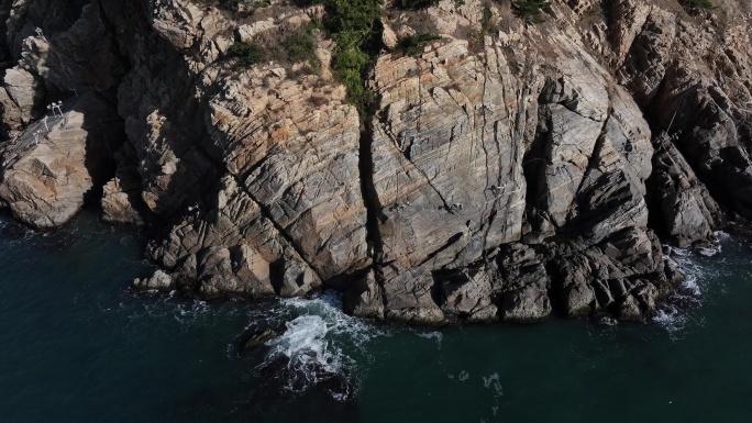航拍威海刘公岛岛后的山崖峭壁海浪礁石