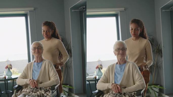 协助在世护士推着坐轮椅的老年妇女穿过客厅