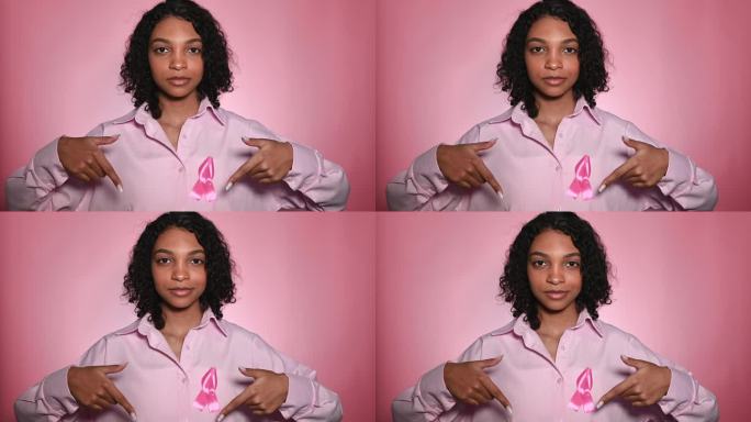 乳腺癌宣传日的概念。女人与粉色丝带指向镜头的底部信息，有用的链接等