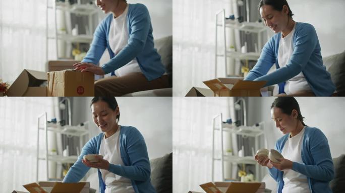 亚洲女性消费者在家中打开纸板箱收到邮包