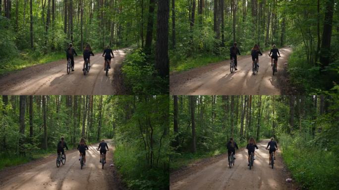 在森林里骑自行车的一群妇女的后视图，周末的学生