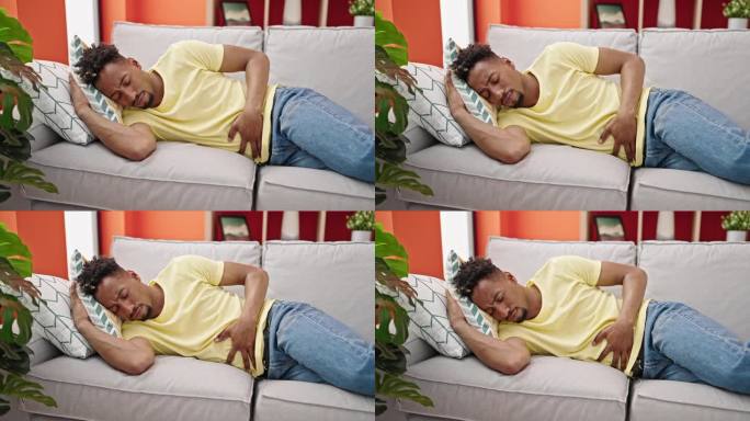 一名非洲裔美国男子因胃痛躺在家里的沙发上