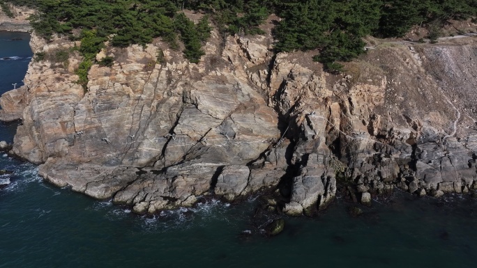 航拍威海刘公岛岛后的山崖峭壁海浪礁石