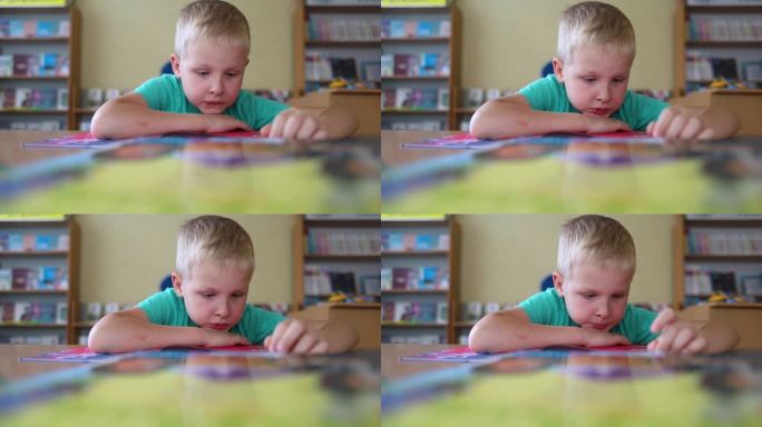 图书馆里的男孩。7岁的乌克兰男孩坐在图书馆的桌子旁看书。学习观念正常，求知欲强，渴望学习新事物。模糊