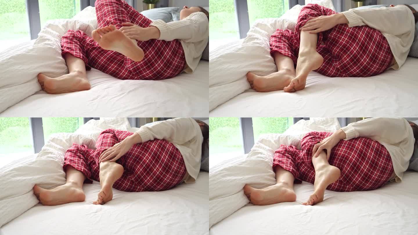 年轻女子躺在床上遭受痉挛或痉挛的特写。伤害的概念，健康问题，疼痛和创伤