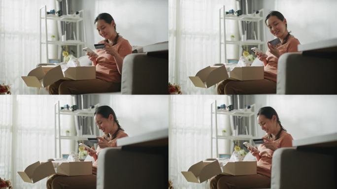 快乐的亚洲女性在家里用智能手机网购