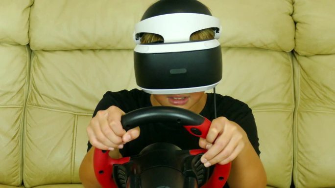 戴着电子游戏头盔的男孩驾驶着汽车模拟器