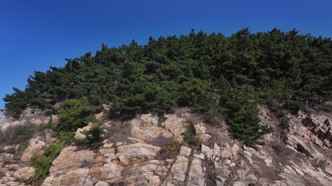 航拍威海刘公岛岛后的山崖峭壁海浪礁石