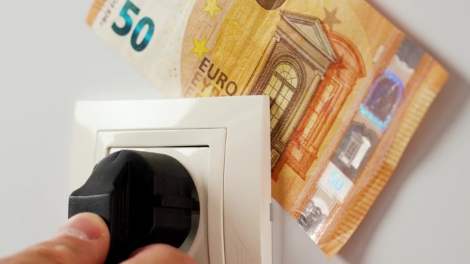 用欧元钞票将电源插头连接到家用插座上。电力成本和节约的财务概念