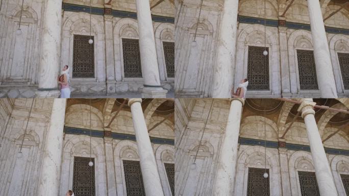 一名妇女站在穆罕默德·阿里帕夏大清真寺的圆柱旁，