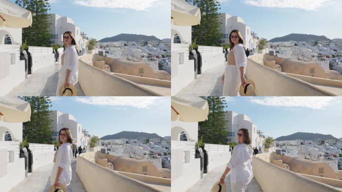 希腊圣托里尼岛伊亚的女游客。快乐的游客走在希腊著名地标圣托里尼岛的楼梯上