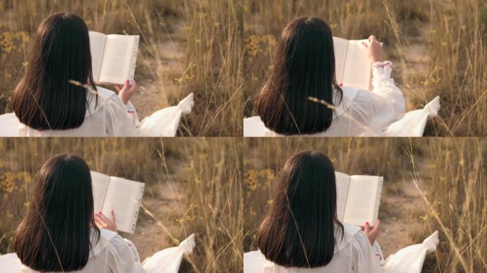 日落时分，一个女人在草地上看书的特写