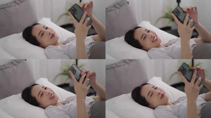 一个亚洲女人在床上看手机