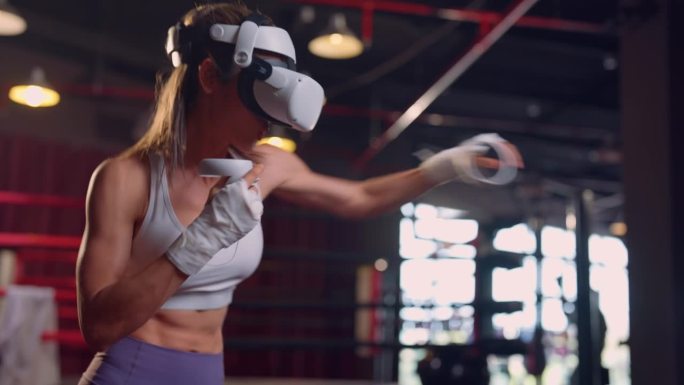 亚洲女运动员使用创新技术VR眼镜进行锻炼。迷人的年轻女孩戴着虚拟现实耳机，拿着游戏控制器，在家里做拳