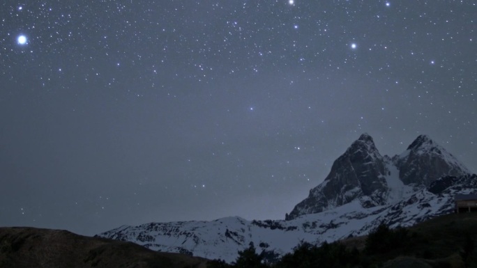 宁静的夜晚，明亮的星星在乌什巴山的天空中移动，雪峰在时间的流逝中消失