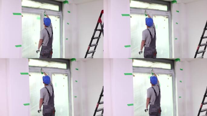 施工人员用白色喷漆粉刷PVC窗层