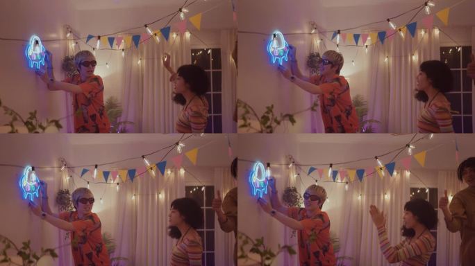 一群朋友来用灯装饰他们房间的墙壁，为新年聚会做准备。