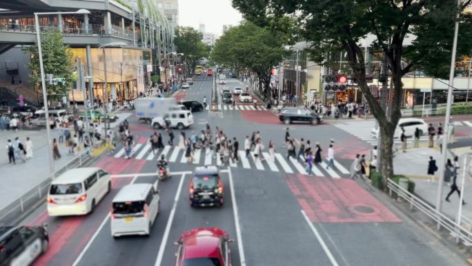 东京涩谷人行横道:街道人行横道上无法辨认的人群与过往的汽车，以及现代城市中心摩天大楼的未来主义城市氛