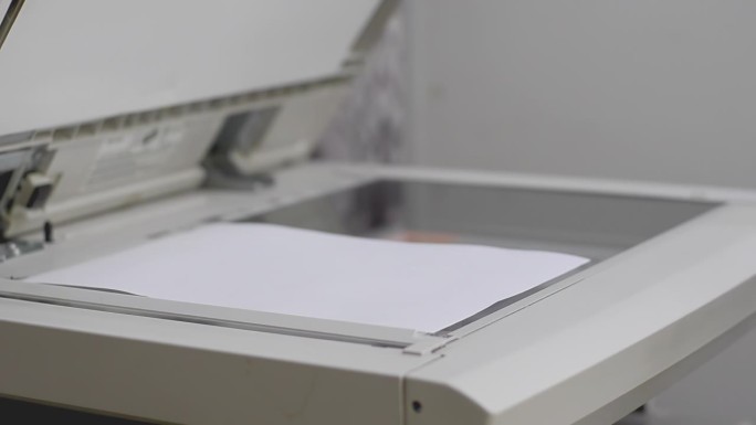 办公室里的女孩在复印机里扫描文件