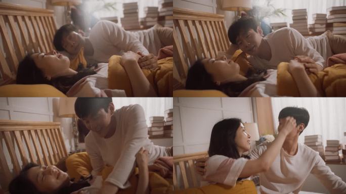 美丽的年轻韩国夫妇睡在床上，体贴的丈夫叫醒他的妻子，准备迎接新的一天。相互支持的生活伴侣，互相表达他