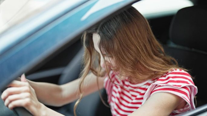 年轻的金发女子紧张地在街上开车
