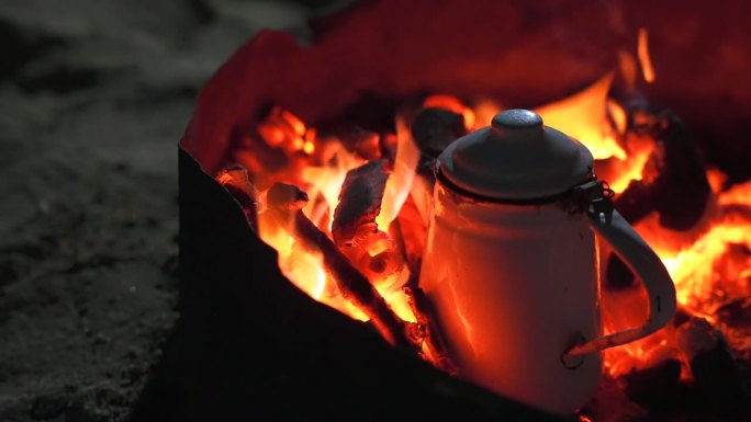 篝火中烧煤的金属水壶近照。晚上在沙漠里泡贝都因茶