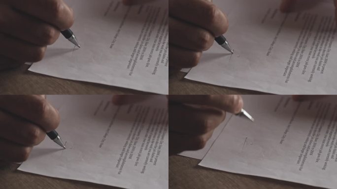 一个人用笔签署文件的特写镜头