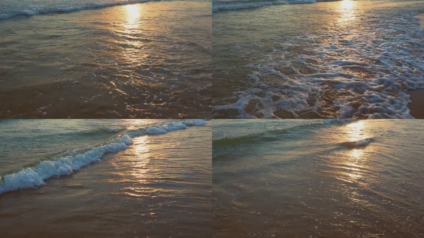 平静的海浪卷过沙滩。日落在海上或海洋。水的运动。海浪掀起阵阵泡沫。旅游的天堂。海滩旅游主题。太阳在波