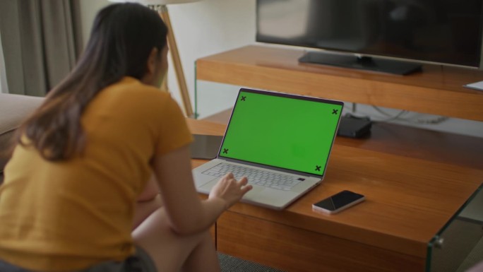 亚洲女性在家使用笔记本电脑绿屏