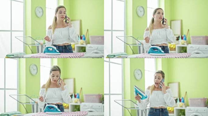 年轻的金发女子用智能手机打电话，在洗衣房用熨烫机烫t恤