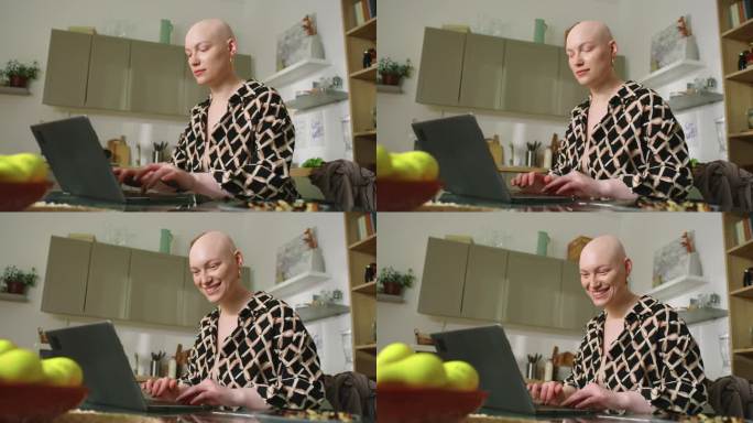 快乐的秃顶女人用笔记本电脑与朋友交流