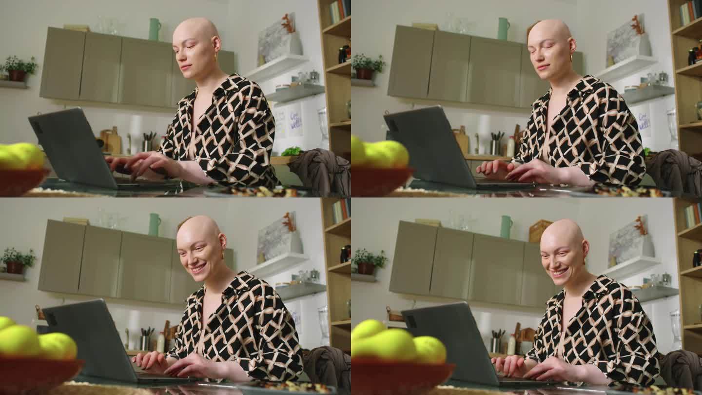 快乐的秃顶女人用笔记本电脑与朋友交流