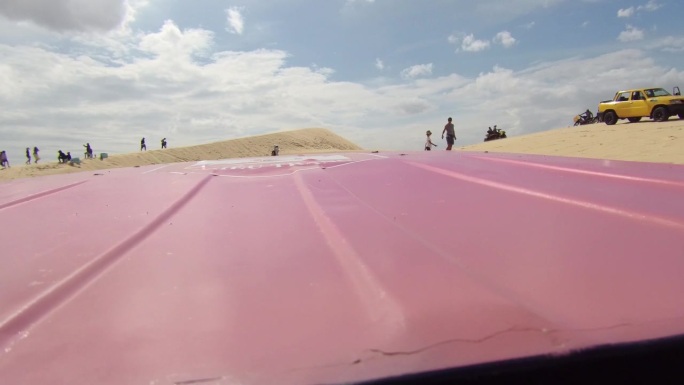 在越南美奈镇的沙丘上，汽车撞沙丘。在阳光明媚的日子里，极限冒险车行驶在沙漠上。