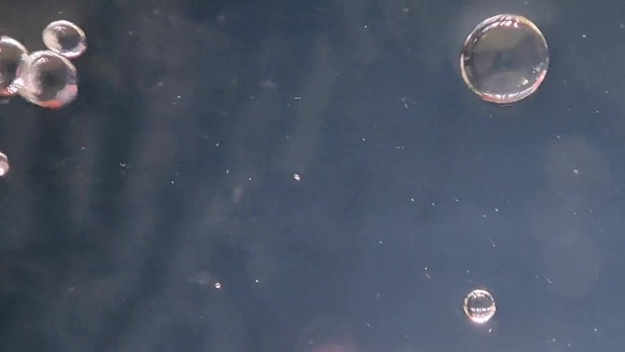 近距离视频，气泡上升的水柱，形成波浪和涟漪的水面上的金鱼水族馆