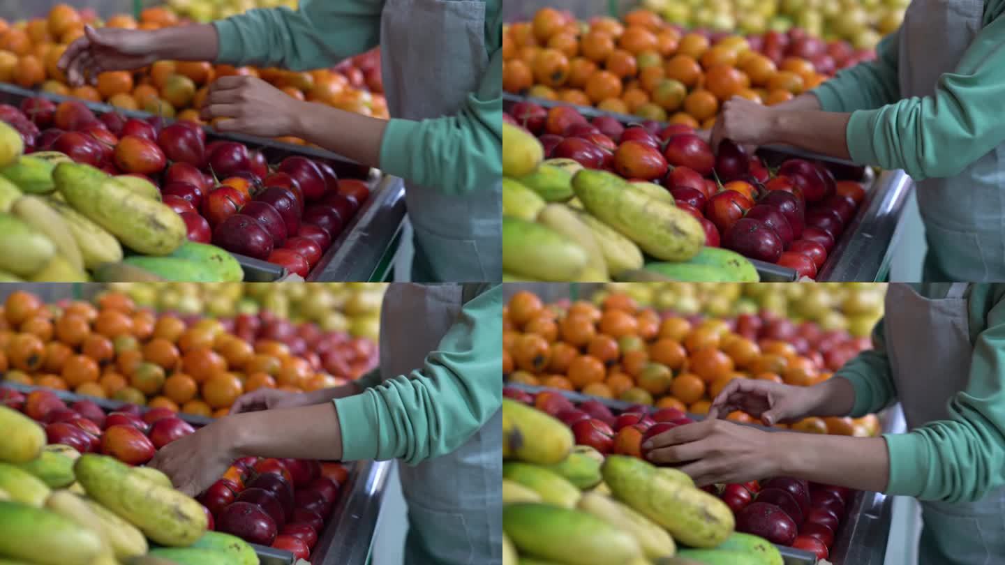 一个面目全非的女人在果蔬市场的零售展台上整理西红柿水果