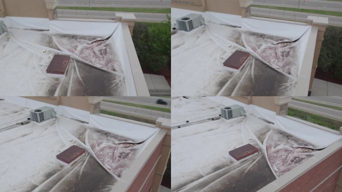 商业建筑屋顶损坏用白色篷布覆盖，空中动态