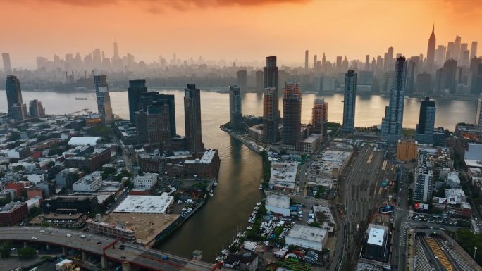 哈德逊河在纽约流动的景象。从高处俯瞰繁忙的大都市。天空中橙色的云景。