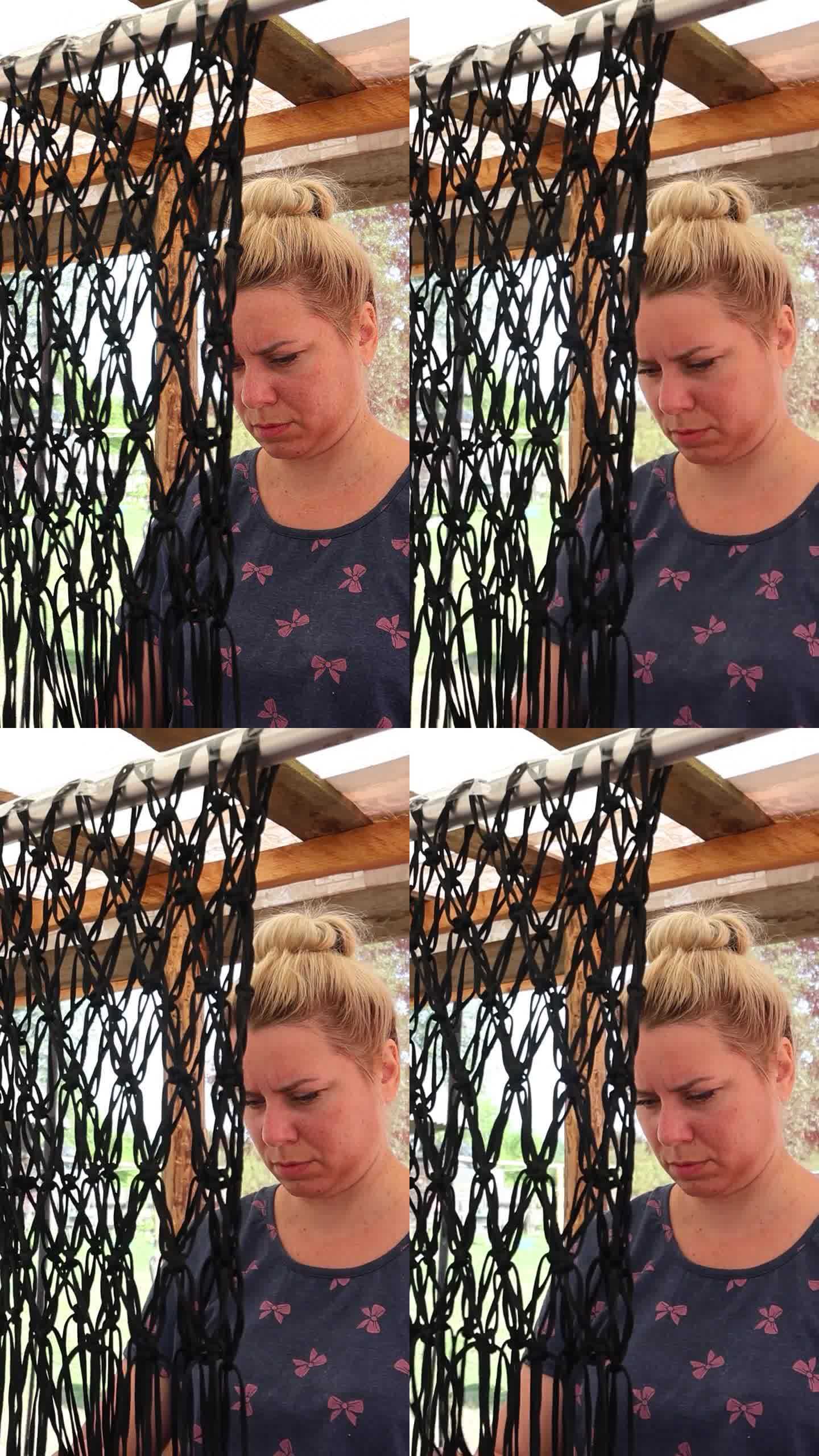 自制购物网。一名妇女用聚合物绳编织一个细绳袋。垂直视频
