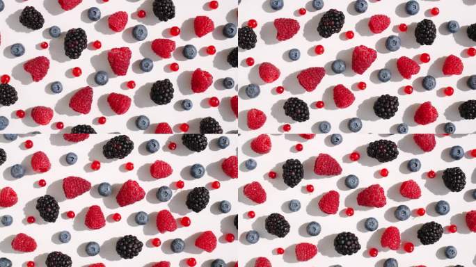 混合新鲜覆盆子，黑莓，蓝莓，红醋栗在一个孤立的白色背景顶部视图模式旋转。健康的水果浆果。新鲜水果小吃