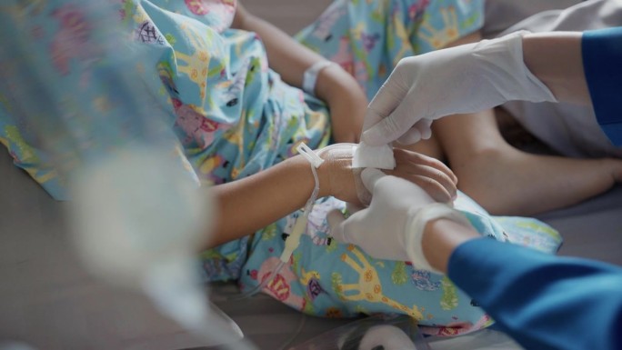友善的护士在病房里照顾孩子们裹着布的手。