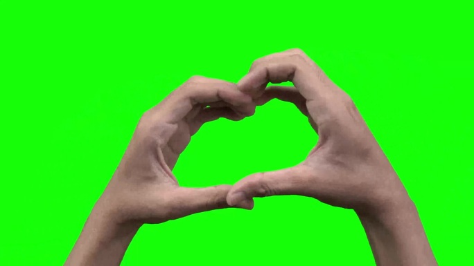 浪漫的爱情标志，双手放在绿色的屏幕上。