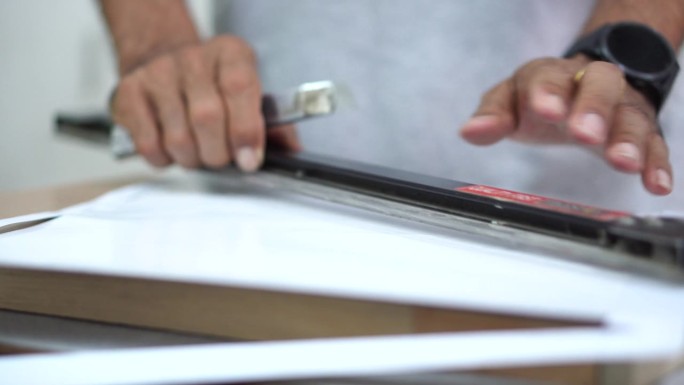 在粘贴到胶合板上之前，专业技术人员用切刀装饰纸张的边缘