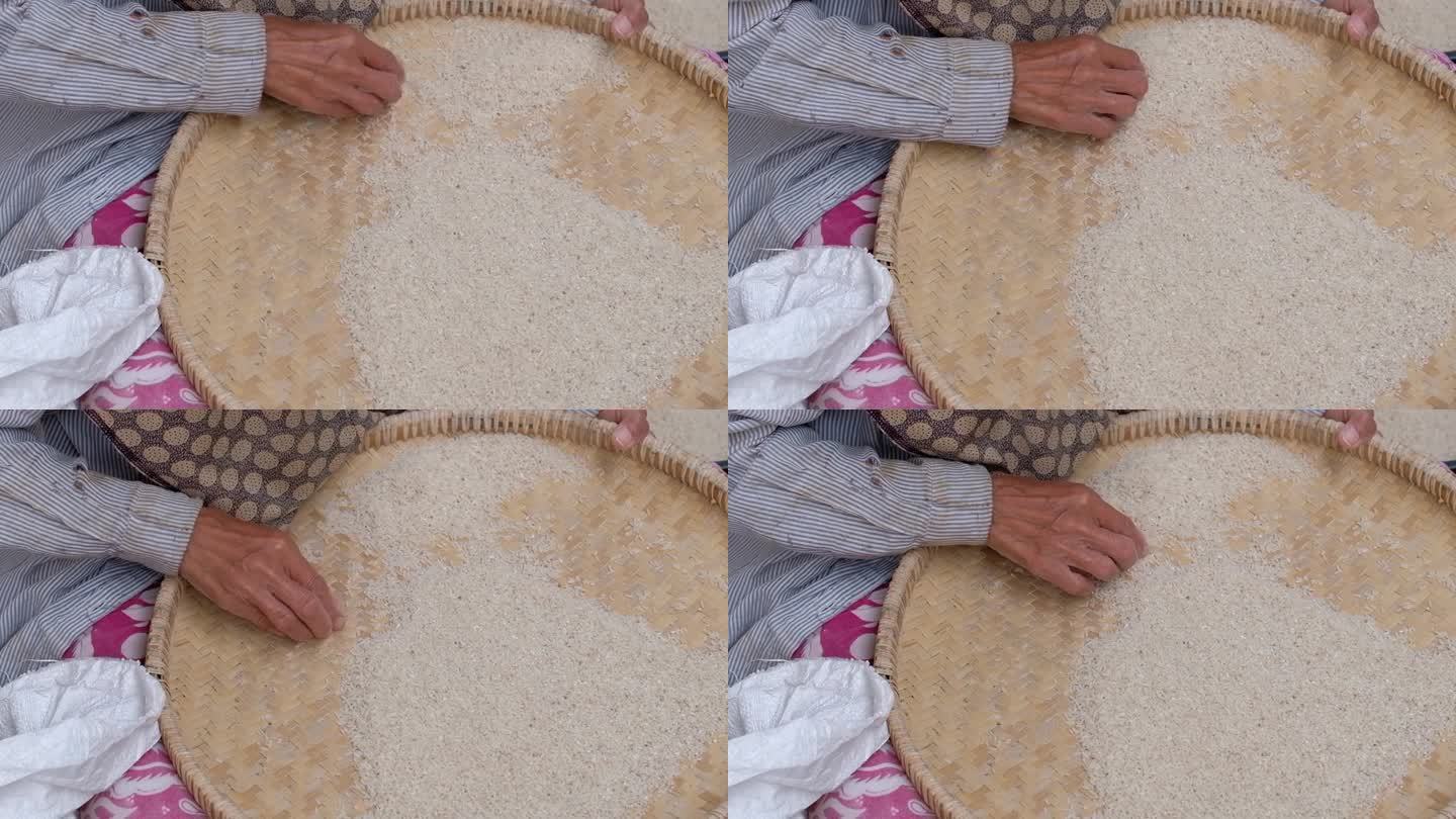 女农民在碾磨后用竹盘清洗稻谷