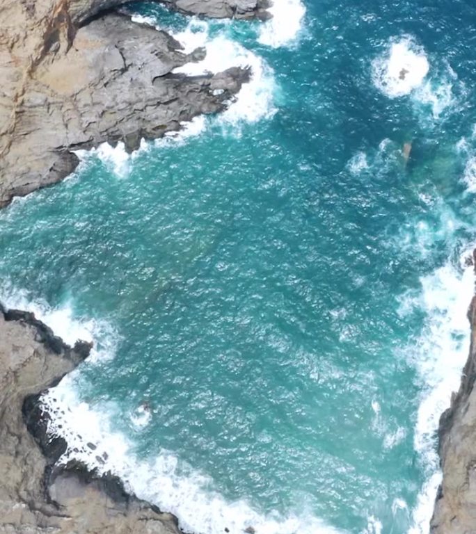 鸟瞰图在戈梅拉岛的一个遥远的岩石上，波浪在岩石上破碎。